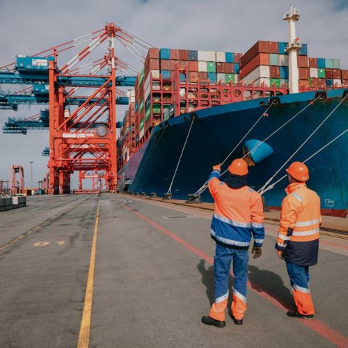 Two workers in front of a port